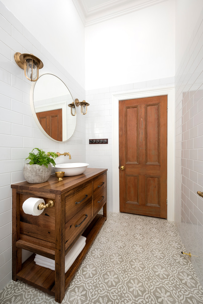Свежая идея для дизайна: главная ванная комната в современном стиле с фасадами островного типа, коричневыми фасадами, белой плиткой, керамической плиткой, белыми стенами, полом из керамогранита, столешницей из дерева, душем с распашными дверями, коричневой столешницей, тумбой под одну раковину и напольной тумбой - отличное фото интерьера