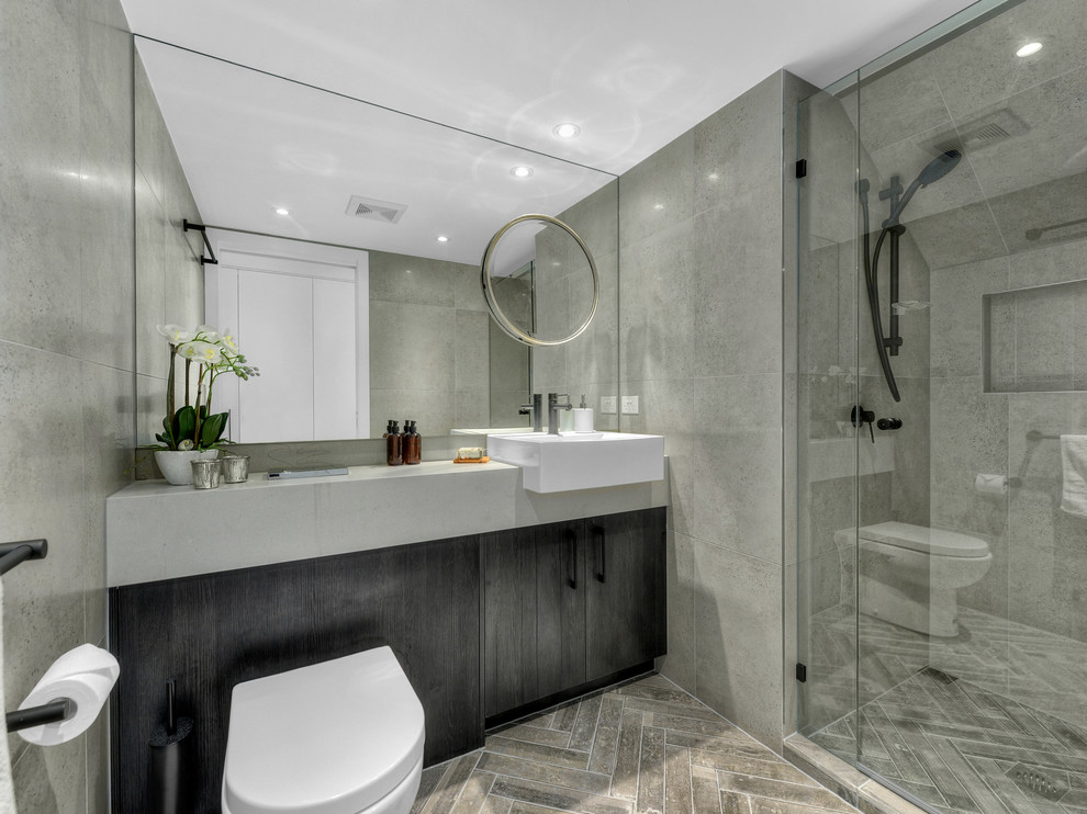 Small urban bathroom in Brisbane with freestanding cabinets, dark wood cabinets, grey tiles, porcelain tiles, ceramic flooring and engineered stone worktops.