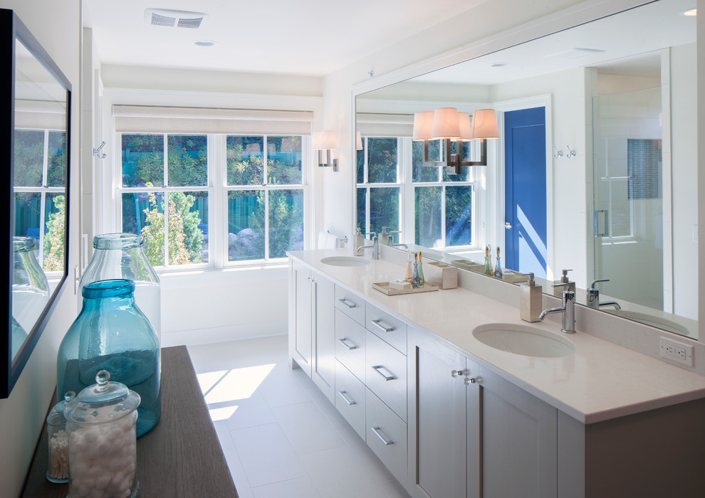 Diseño de cuarto de baño marinero con lavabo bajoencimera, armarios estilo shaker, puertas de armario grises y paredes blancas