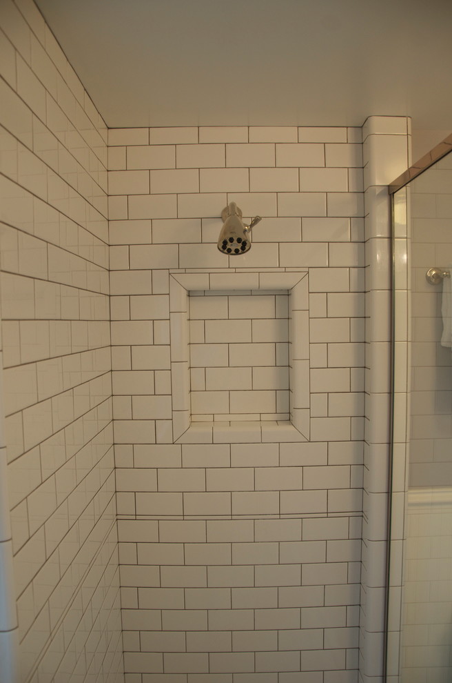Diseño de cuarto de baño clásico de tamaño medio con ducha empotrada, baldosas y/o azulejos blancos, baldosas y/o azulejos de cemento, paredes blancas, suelo con mosaicos de baldosas, aseo y ducha, lavabo con pedestal, suelo gris y ducha con puerta con bisagras