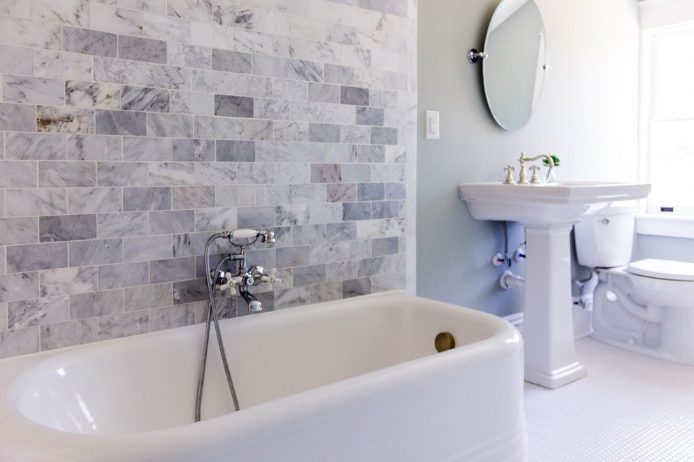 Ejemplo de cuarto de baño grande con puertas de armario blancas, encimera de azulejos, bañera exenta, sanitario de pared y paredes azules