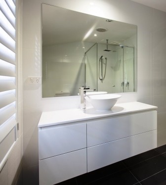 Idéer för att renovera ett litet funkis en-suite badrum, med ett fristående handfat, vita skåp, bänkskiva i akrylsten, en öppen dusch, en toalettstol med separat cisternkåpa, vit kakel, keramikplattor, vita väggar och travertin golv