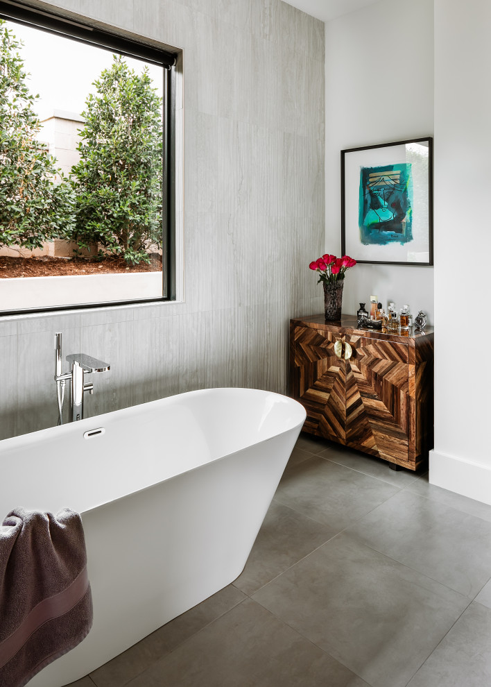 Modern inredning av ett badrum, med ett fristående badkar, grå kakel och stenkakel