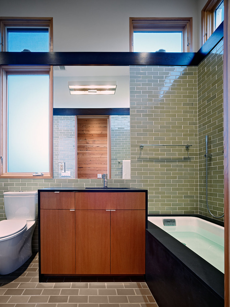 Photo of a contemporary bathroom in San Francisco with flat-panel cabinets, medium wood cabinets, an alcove bath, green tiles and metro tiles.