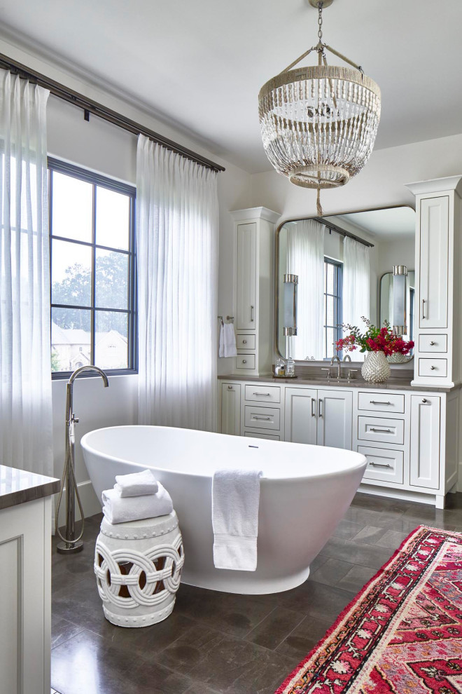 Example of a transitional gray floor freestanding bathtub design in Atlanta with shaker cabinets, white cabinets, white walls, an undermount sink and brown countertops