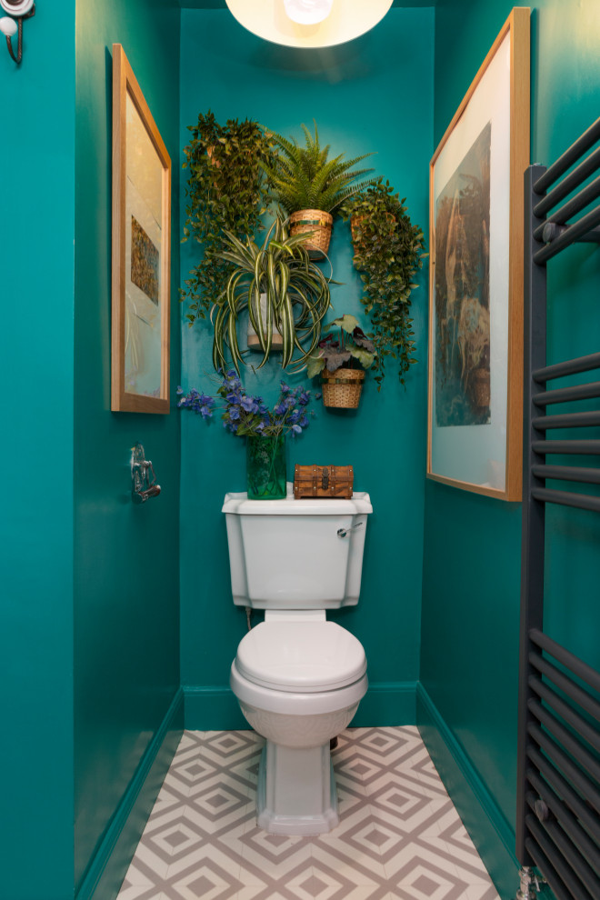 На фото: туалет среднего размера в стиле фьюжн с зелеными стенами, полом из линолеума, серым полом и раздельным унитазом