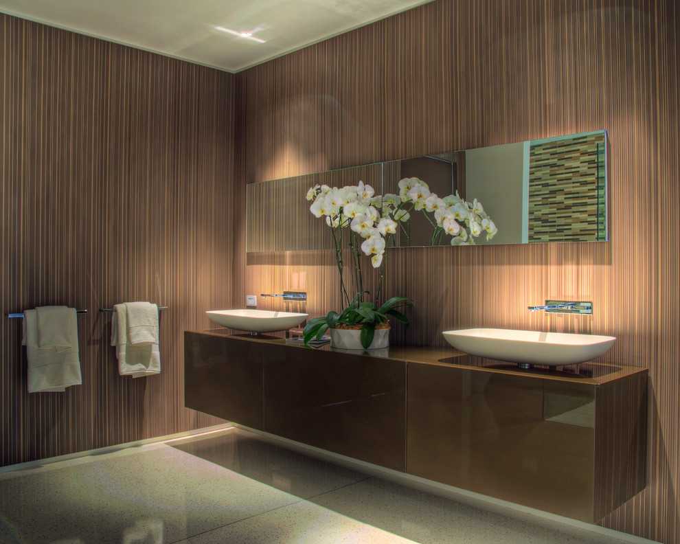Exemple d'une grande salle de bain principale tendance en bois foncé avec un placard à porte plane, un mur marron, une vasque et un sol gris.