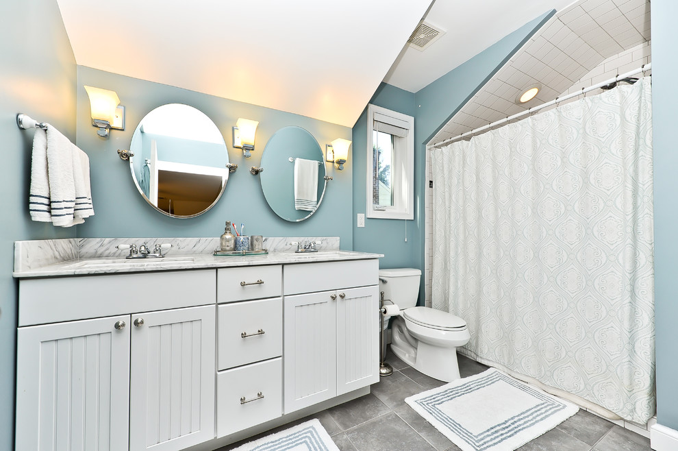 Imagen de cuarto de baño clásico con armarios estilo shaker, puertas de armario blancas, ducha empotrada y baldosas y/o azulejos grises