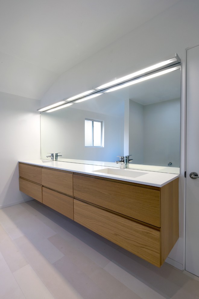 Bathroom - mid-sized modern master white tile and stone tile limestone floor bathroom idea in Los Angeles with an integrated sink, flat-panel cabinets, light wood cabinets, quartz countertops and white walls
