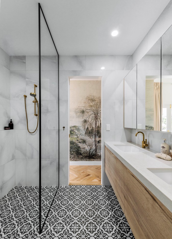 Nautical ensuite bathroom in Brisbane with light wood cabinets, a walk-in shower, white tiles, ceramic tiles, ceramic flooring, a submerged sink, black floors, an open shower, white worktops, flat-panel cabinets and grey walls.