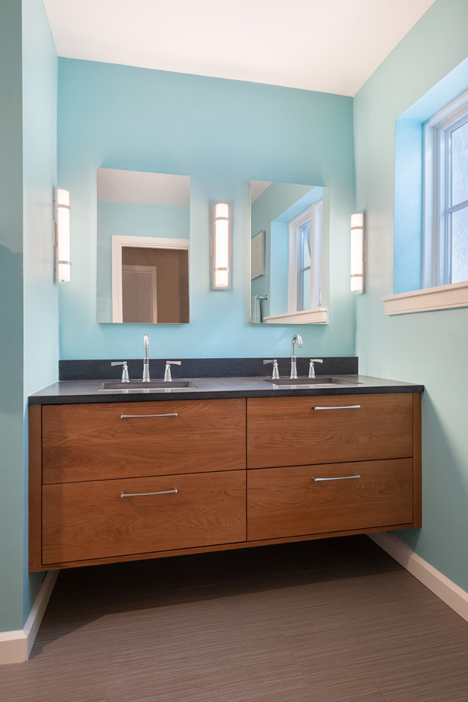 Ispirazione per una piccola stanza da bagno padronale minimalista con ante lisce, ante marroni, pareti blu, pavimento con piastrelle in ceramica, lavabo sottopiano, top in onice, pavimento marrone e top nero