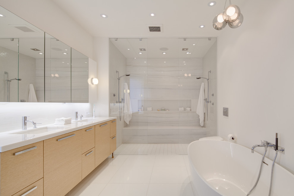 Foto de cuarto de baño principal contemporáneo con armarios con paneles lisos, puertas de armario de madera clara, bañera exenta, ducha abierta, paredes blancas, lavabo bajoencimera y ducha abierta