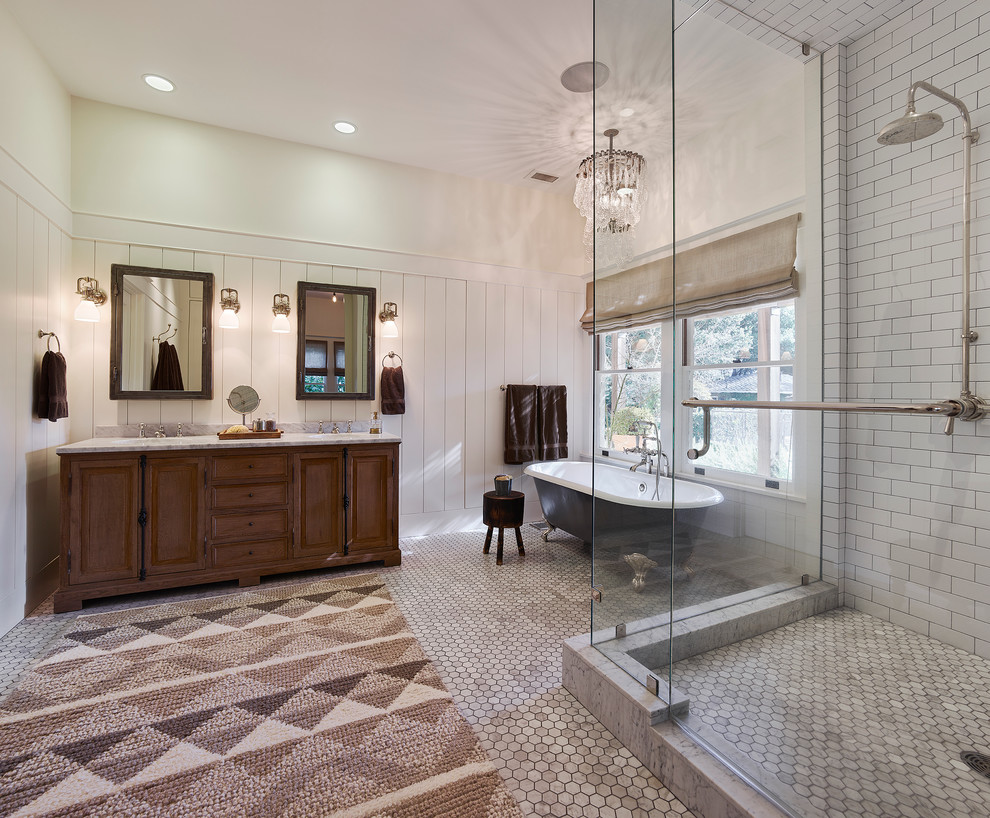 Cette photo montre une salle de bain chic en bois foncé avec une baignoire sur pieds, une douche d'angle, un carrelage blanc, un mur blanc, un sol en carrelage de terre cuite, un lavabo encastré et un placard avec porte à panneau surélevé.