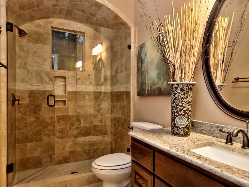 Inspiration for a medium sized traditional bathroom in Austin with raised-panel cabinets, dark wood cabinets, granite worktops, beige tiles, stone tiles, an alcove shower, a submerged sink, beige walls and travertine flooring.