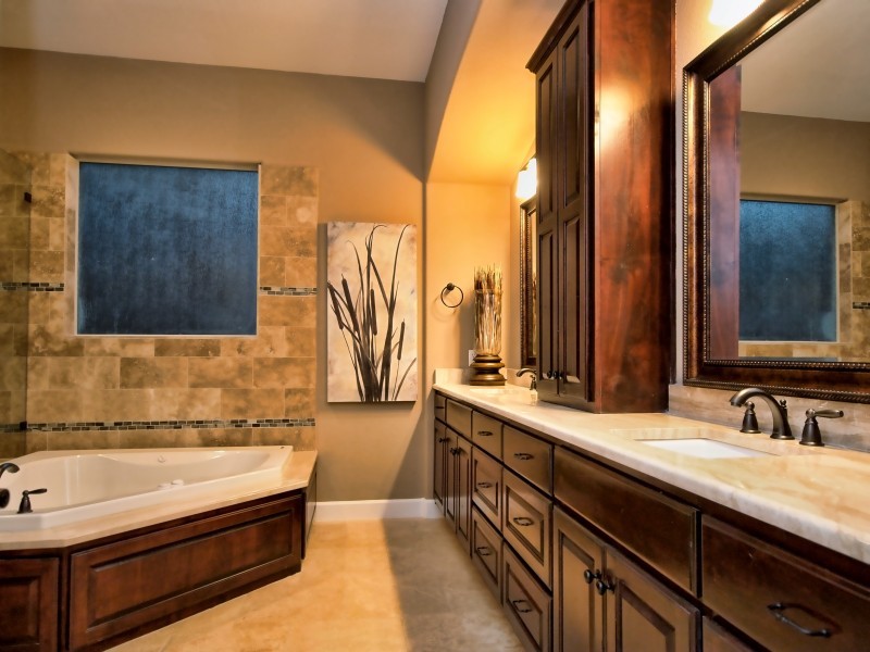 Idéer för ett stort klassiskt en-suite badrum, med luckor med upphöjd panel, skåp i mörkt trä, granitbänkskiva, beige kakel, stenkakel, ett hörnbadkar, ett undermonterad handfat, beige väggar och travertin golv