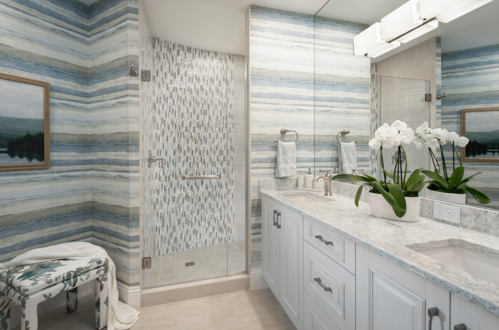 Inspiration for a coastal 3/4 multicolored tile and matchstick tile beige floor, double-sink and wallpaper corner shower remodel in Miami with raised-panel cabinets, white cabinets, multicolored walls, an undermount sink, a hinged shower door, multicolored countertops and a floating vanity