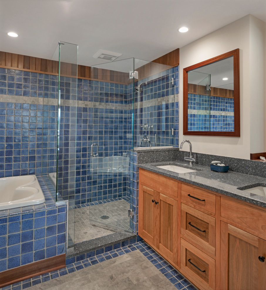 Design ideas for a medium sized contemporary bathroom in Portland Maine with recessed-panel cabinets, medium wood cabinets, a built-in bath, a corner shower, blue tiles, beige walls, a submerged sink, blue floors, a hinged door and grey worktops.