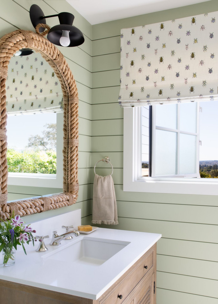 Klassisches Badezimmer mit Lamellenschränken, hellbraunen Holzschränken, grüner Wandfarbe, Unterbauwaschbecken, weißer Waschtischplatte, Einzelwaschbecken und Holzdielenwänden in San Francisco