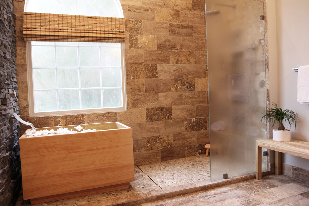 Пример оригинального дизайна: большая главная ванная комната в восточном стиле с плоскими фасадами, черными фасадами, японской ванной, открытым душем, раздельным унитазом, бежевой плиткой, черной плиткой, коричневой плиткой, серой плиткой, разноцветной плиткой, каменной плиткой, серыми стенами, полом из травертина и настольной раковиной