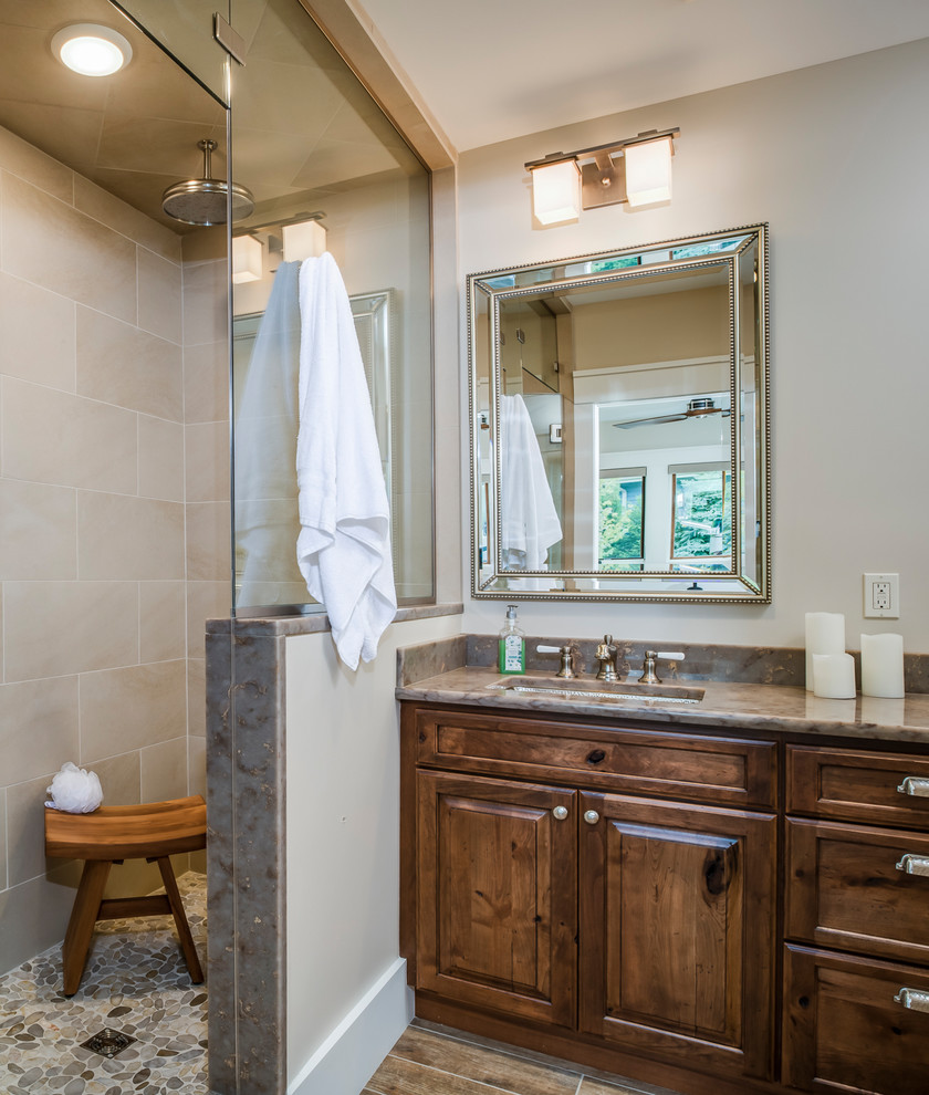 This is an example of a traditional ensuite bathroom in Other with raised-panel cabinets, medium wood cabinets, an alcove shower, beige tiles, beige walls, ceramic flooring, a submerged sink, granite worktops, brown floors and a hinged door.