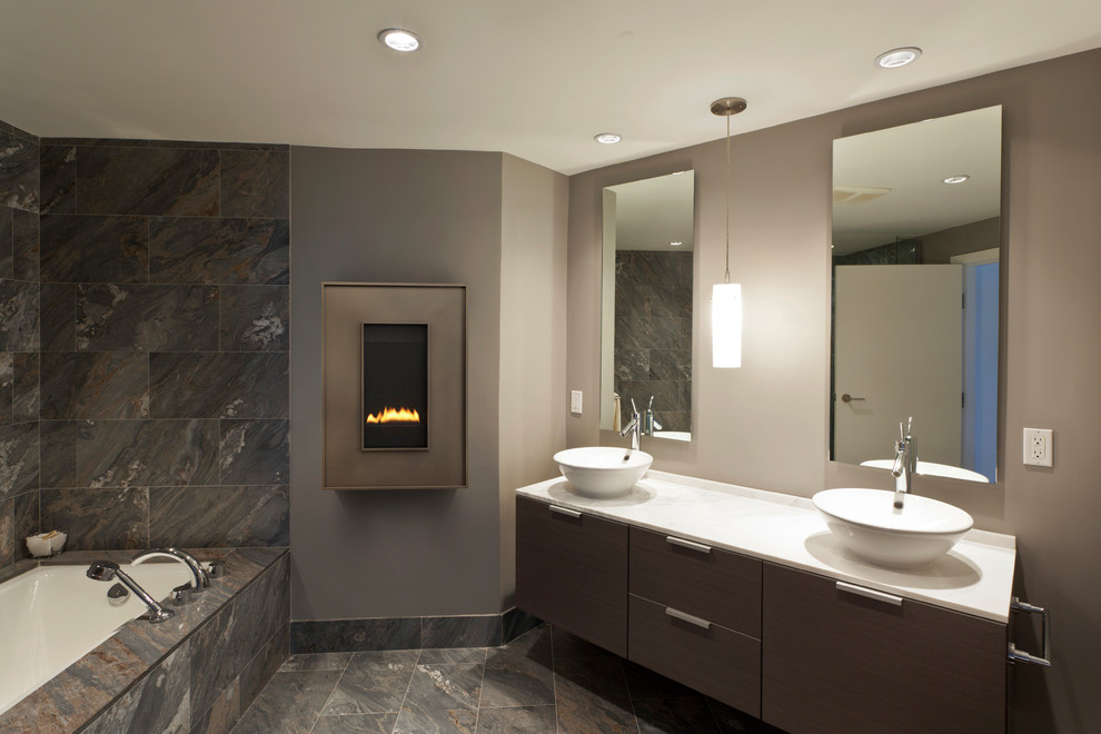 Modern inredning av ett mellanstort en-suite badrum, med släta luckor, skåp i mörkt trä, ett undermonterat badkar, grå kakel, skifferkakel, grå väggar, skiffergolv, ett fristående handfat, bänkskiva i akrylsten och grått golv
