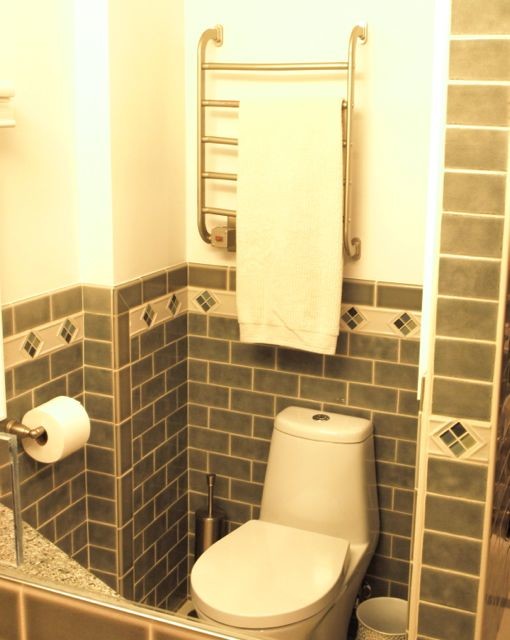 Inspiration for a small classic family bathroom in Newark with flat-panel cabinets, white cabinets, an alcove bath, a shower/bath combination, a one-piece toilet, green tiles, ceramic tiles, white walls, ceramic flooring, a submerged sink, granite worktops, white floors and a shower curtain.