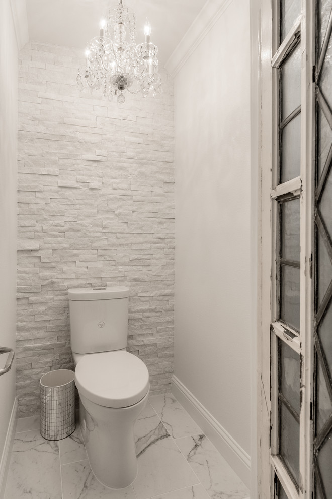 Cette image montre un grand WC et toilettes design avec un placard avec porte à panneau surélevé, des portes de placard blanches, WC séparés, un carrelage gris, un carrelage blanc, un carrelage de pierre, un mur blanc, un sol en marbre, un lavabo encastré et un plan de toilette en marbre.