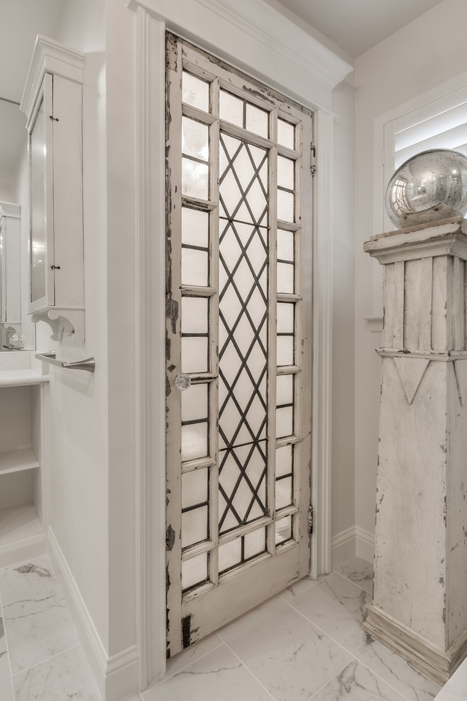 Exemple d'une grande douche en alcôve principale tendance avec un placard avec porte à panneau surélevé, des portes de placard blanches, un carrelage gris, un carrelage blanc, un carrelage de pierre, un mur blanc, un sol en marbre, un lavabo encastré et un plan de toilette en marbre.