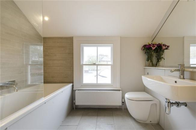 Idee per una piccola stanza da bagno minimalista con lavabo sospeso, top in marmo, vasca/doccia, WC sospeso, piastrelle grigie, piastrelle in ceramica, pareti beige e pavimento con piastrelle in ceramica
