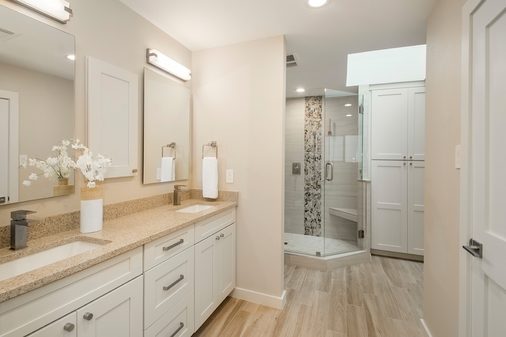Large classic ensuite bathroom in Dallas with beige walls, light hardwood flooring, beige floors, flat-panel cabinets, white cabinets, an alcove bath, a corner shower, a one-piece toilet, beige tiles, porcelain tiles, a submerged sink, engineered stone worktops and a hinged door.