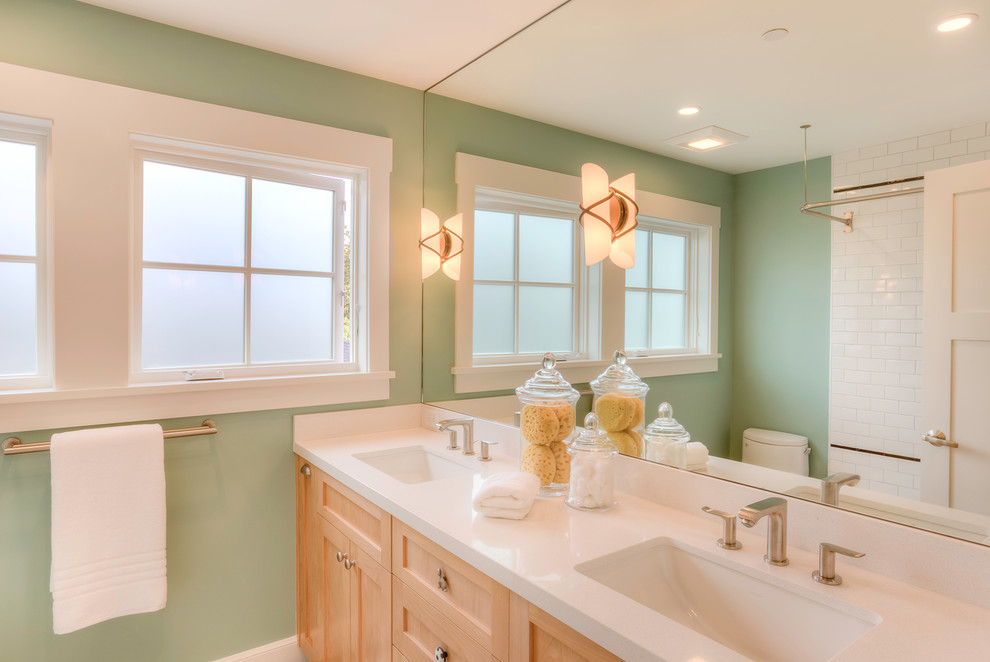 Foto di una stanza da bagno con doccia american style con ante in stile shaker, ante in legno chiaro, vasca ad angolo, vasca/doccia, pareti verdi e lavabo sottopiano