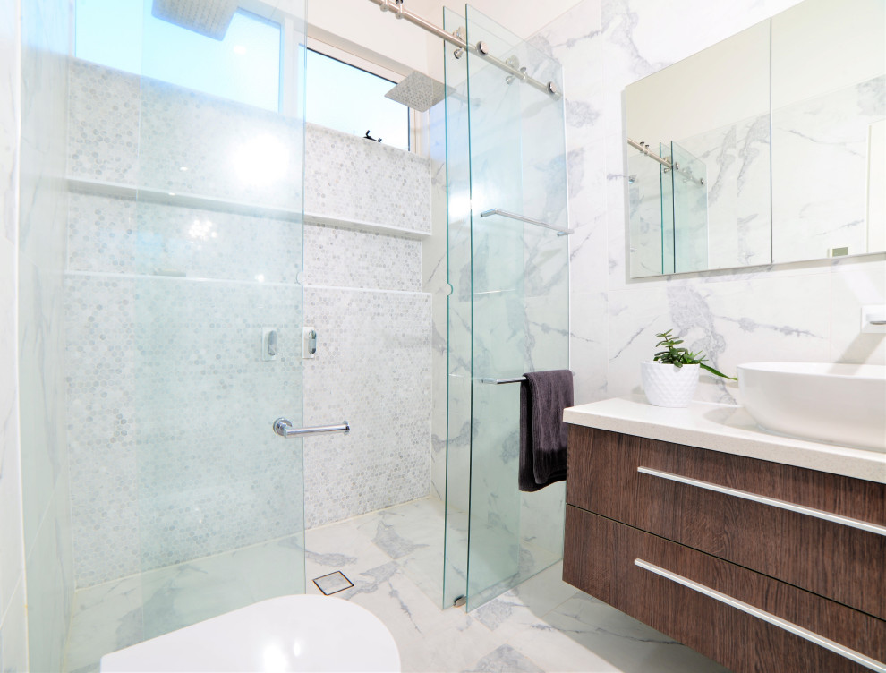 На фото: главная ванная комната среднего размера в стиле ретро с накладной ванной, двойным душем, унитазом-моноблоком, белой плиткой, керамогранитной плиткой, белыми стенами, полом из керамогранита, настольной раковиной, столешницей из переработанного стекла, белым полом, душем с раздвижными дверями, белой столешницей, тумбой под одну раковину и подвесной тумбой
