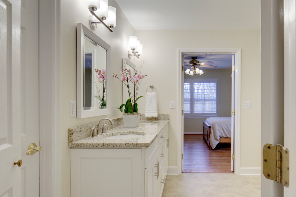 Example of a mid-sized classic master beige tile and porcelain tile porcelain tile and beige floor corner shower design in Birmingham with an undermount sink, shaker cabinets, white cabinets, granite countertops, a two-piece toilet and beige walls