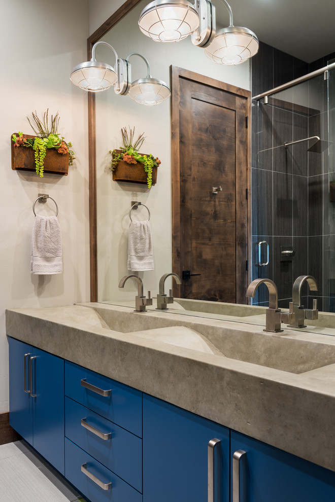 Example of a mountain style bathroom design in Salt Lake City with flat-panel cabinets, blue cabinets, white walls, an integrated sink, concrete countertops and gray countertops