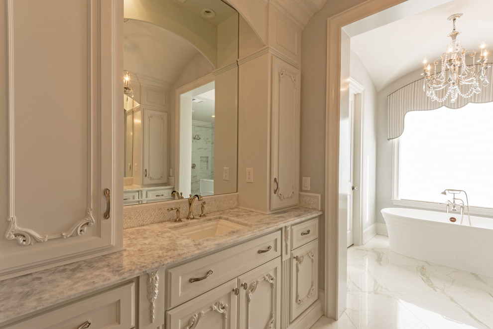 Large classic ensuite bathroom in Houston with freestanding cabinets, white cabinets, a freestanding bath, a corner shower, grey walls, ceramic flooring, a submerged sink, quartz worktops, white floors, a hinged door and white worktops.