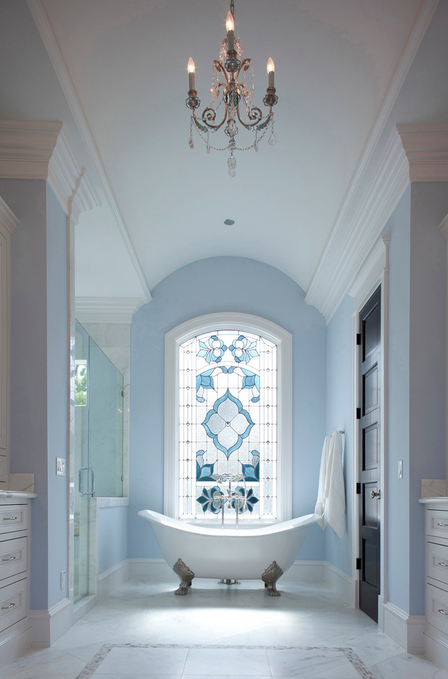 Klassisches Badezimmer mit Schrankfronten mit vertiefter Füllung, weißen Schränken, Löwenfuß-Badewanne, Duschnische und blauer Wandfarbe in Houston