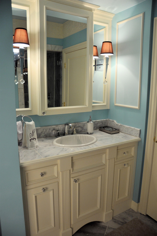 Foto de cuarto de baño tradicional pequeño con lavabo encastrado, armarios con paneles con relieve, puertas de armario blancas, encimera de cuarzo compacto, paredes azules, suelo de baldosas de cerámica y aseo y ducha