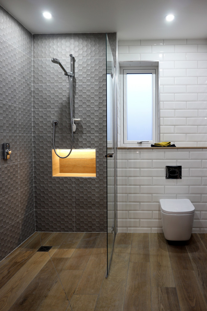 Пример оригинального дизайна: большая главная, серо-белая ванная комната в стиле модернизм с темными деревянными фасадами, душевой комнатой, инсталляцией, белой плиткой, плиткой кабанчик, серыми стенами, полом из керамической плитки, консольной раковиной, коричневым полом, тумбой под одну раковину, напольной тумбой и открытым душем