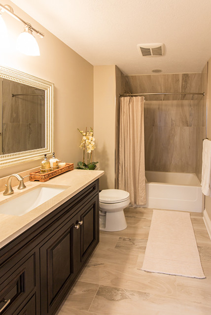 Photo of a medium sized traditional shower room bathroom in Other with raised-panel cabinets, black cabinets, an alcove bath, a shower/bath combination, a two-piece toilet, beige walls, porcelain flooring, a submerged sink, granite worktops, beige floors and a shower curtain.