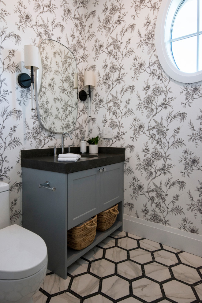 Идея дизайна: ванная комната в стиле неоклассика (современная классика) с фасадами в стиле шейкер, серыми фасадами, серыми стенами, врезной раковиной, разноцветным полом, черной столешницей, тумбой под одну раковину, встроенной тумбой, обоями на стенах и столешницей из искусственного кварца