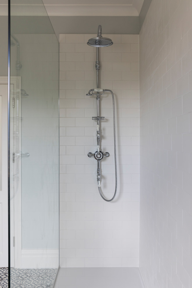 На фото: ванная комната в стиле неоклассика (современная классика) с открытым душем, белой плиткой, синими стенами и полом из керамической плитки с