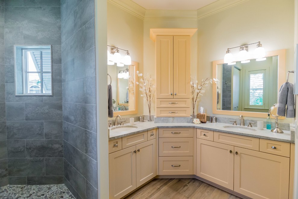 Photo of a medium sized coastal ensuite bathroom in Miami with a built-in sink, shaker cabinets, yellow cabinets, granite worktops, a walk-in shower, a one-piece toilet, grey tiles, ceramic tiles, yellow walls and ceramic flooring.