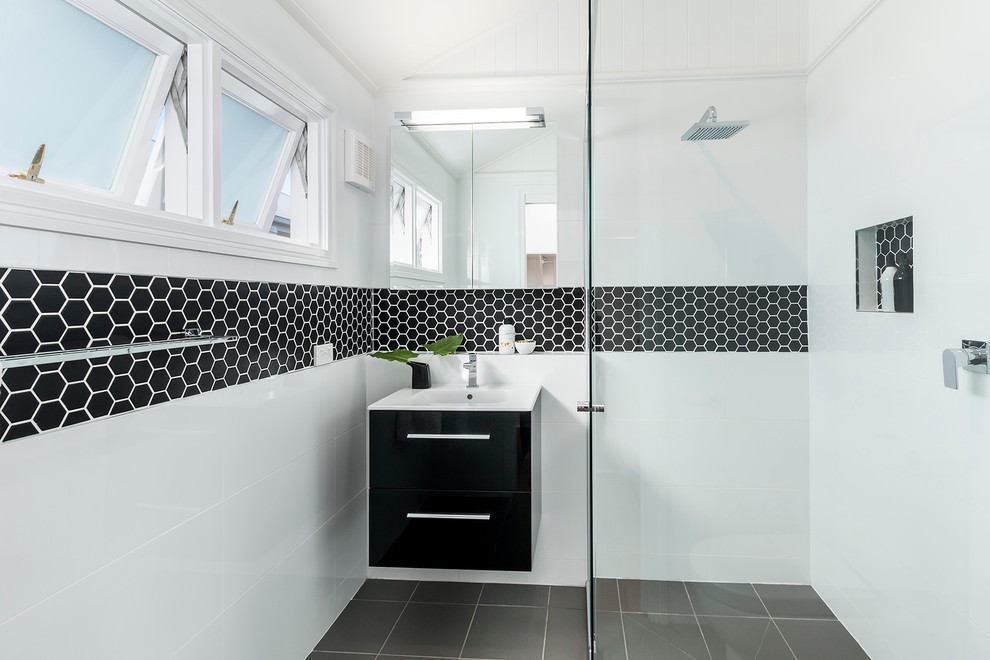 Bild på ett litet funkis badrum med dusch, med släta luckor, svarta skåp, en kantlös dusch, vita väggar, klinkergolv i keramik och svart och vit kakel