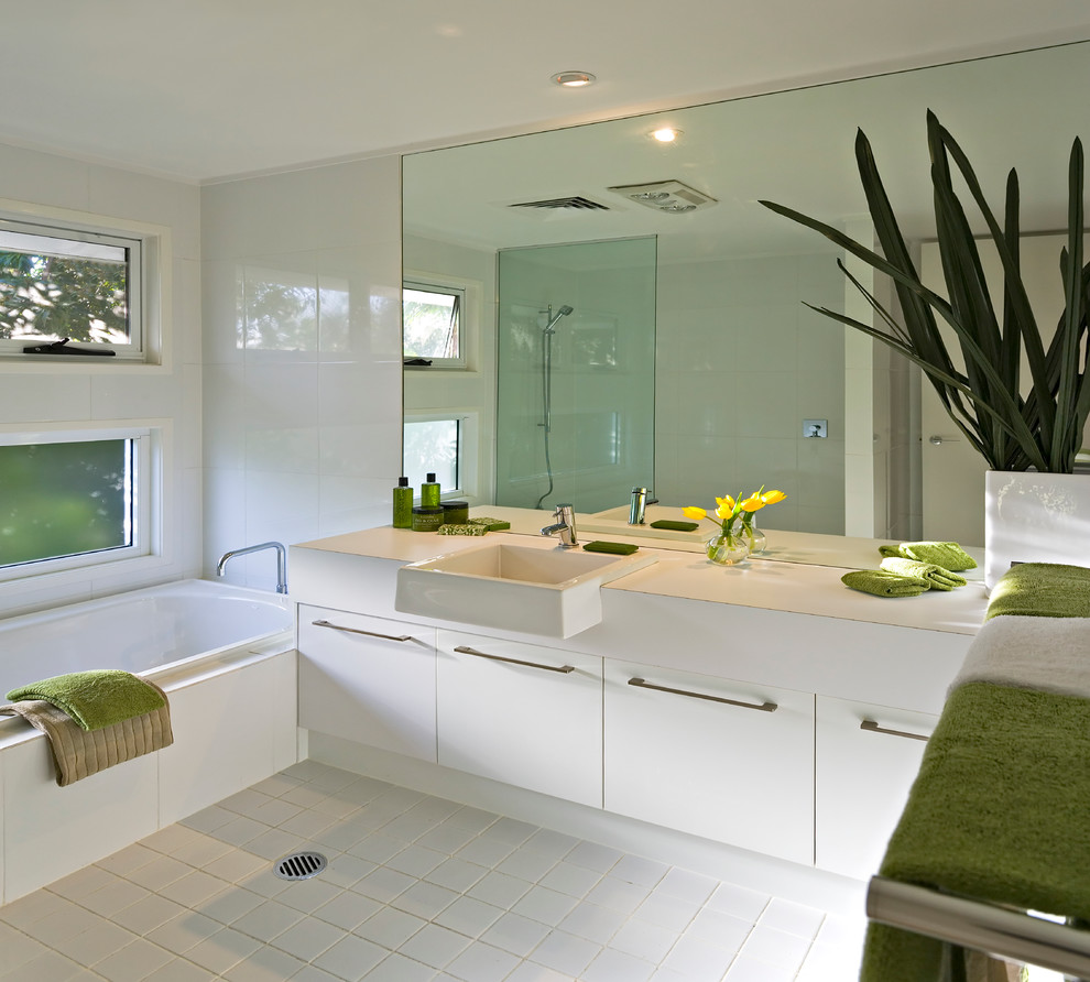 Modernes Badezimmer mit weißen Schränken, weißen Fliesen, Keramikfliesen, Keramikboden, flächenbündigen Schrankfronten, Badewanne in Nische und weißer Wandfarbe in Brisbane