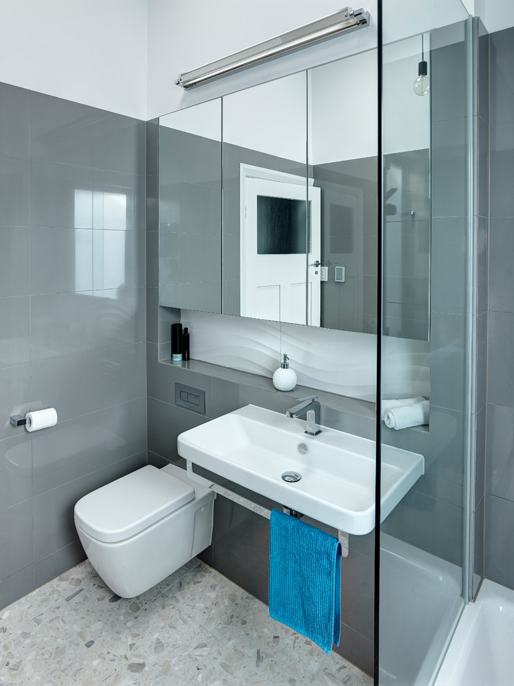 Пример оригинального дизайна: маленькая ванная комната в современном стиле с накладной ванной, душем над ванной, инсталляцией, серой плиткой, керамогранитной плиткой, белыми стенами и мраморным полом для на участке и в саду