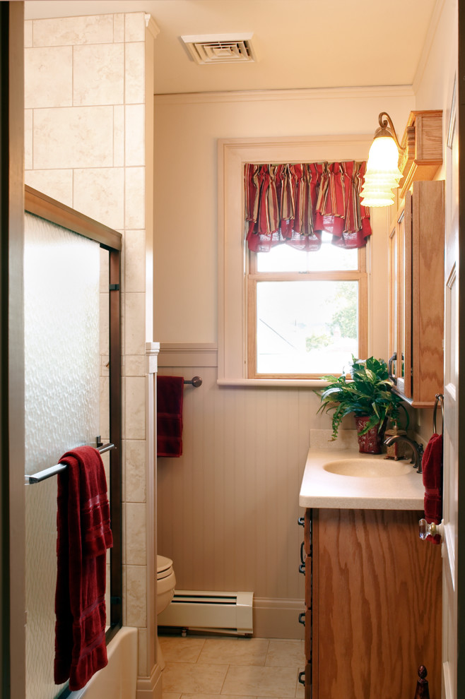 Kleines Country Duschbad mit Kassettenfronten, hellen Holzschränken, Duschbadewanne, weißer Wandfarbe, Travertin, integriertem Waschbecken und Mineralwerkstoff-Waschtisch in Cincinnati