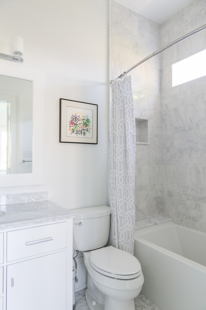 Inspiration for a small traditional shower room bathroom in New Orleans with shaker cabinets, white cabinets, an alcove bath, a shower/bath combination, a two-piece toilet, grey tiles, white tiles, white walls, mosaic tile flooring, a submerged sink and marble worktops.
