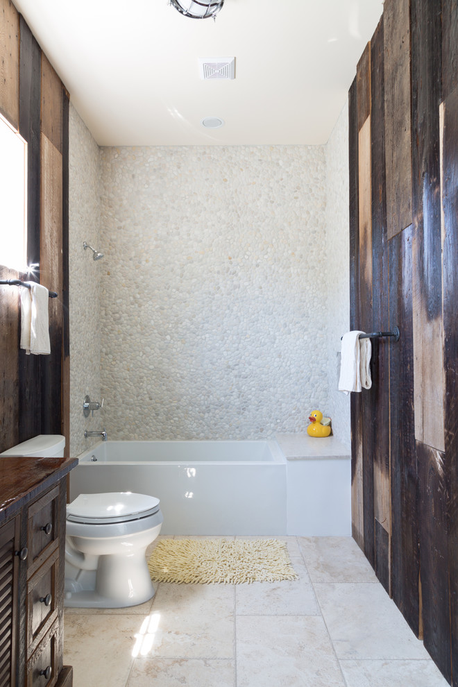 Idéer för att renovera ett litet rustikt brun brunt badrum med dusch, med skåp i shakerstil, skåp i mörkt trä, en dusch/badkar-kombination, vit kakel, kakel i småsten, träbänkskiva, en toalettstol med separat cisternkåpa, bruna väggar, klinkergolv i keramik och ett undermonterad handfat