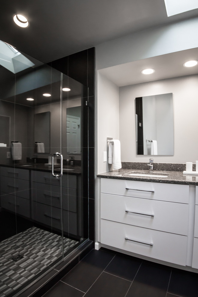 Пример оригинального дизайна: главная ванная комната среднего размера в современном стиле с плоскими фасадами, белыми фасадами, отдельно стоящей ванной, душем в нише, черной плиткой, керамогранитной плиткой, белыми стенами, полом из керамогранита, врезной раковиной, столешницей из гранита, черным полом и душем с распашными дверями