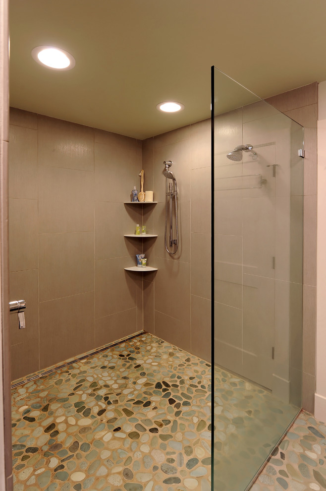 Modern inredning av ett badrum, med klinkergolv i småsten och en kantlös dusch